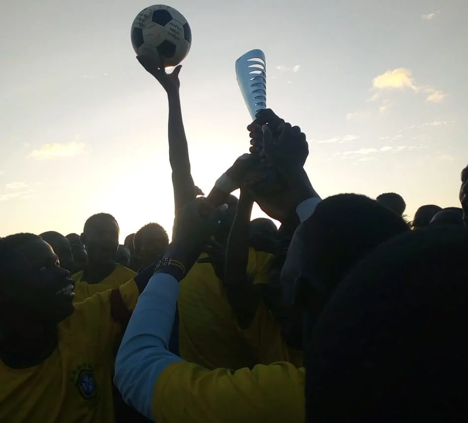 Members of the Rapid Deployment Unit lift the trophy for the Amani Ni Mimi community football match