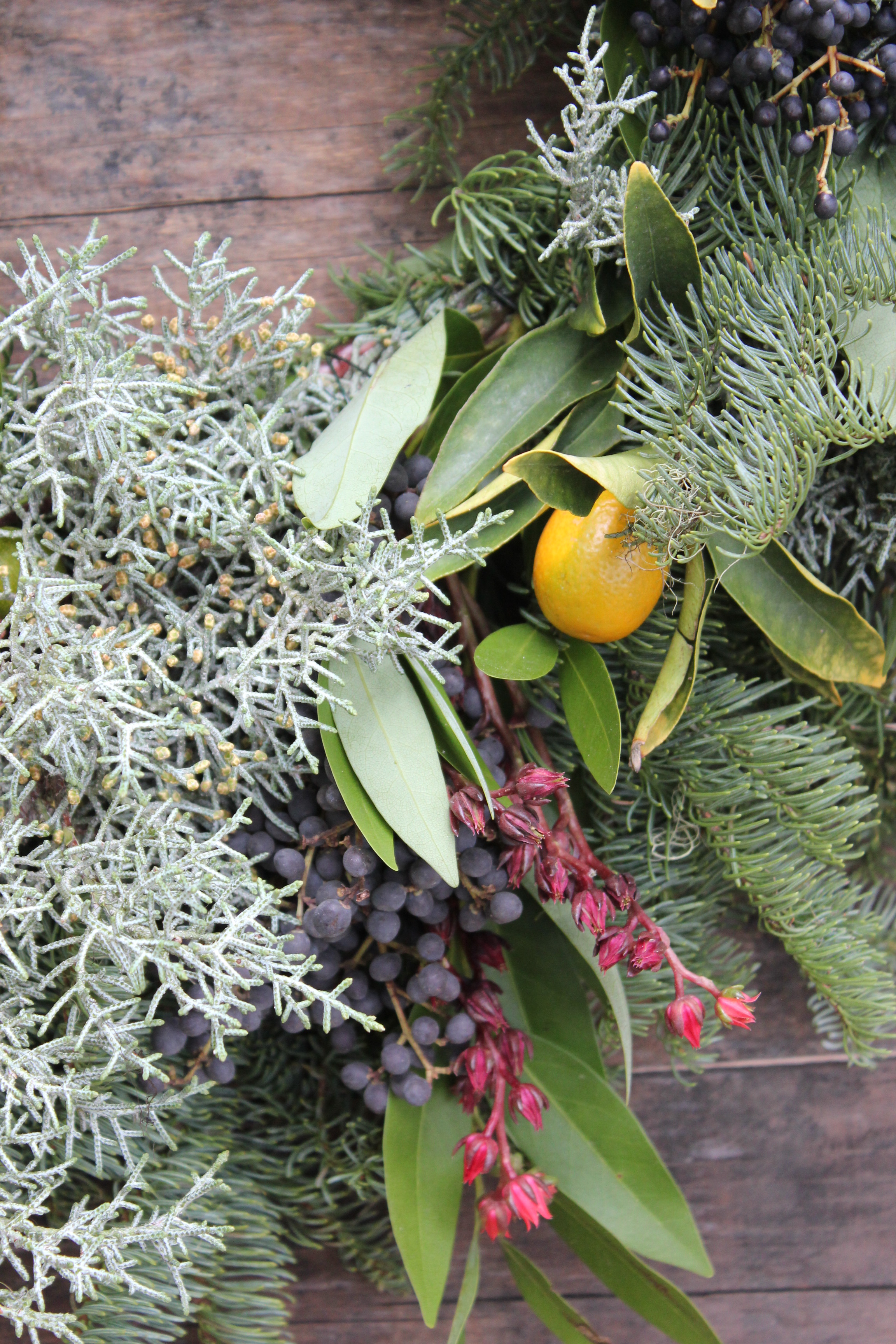 A combinations of firs, bay laurel, privett, kumquats, and pink succulent blossoms make for great texture.
