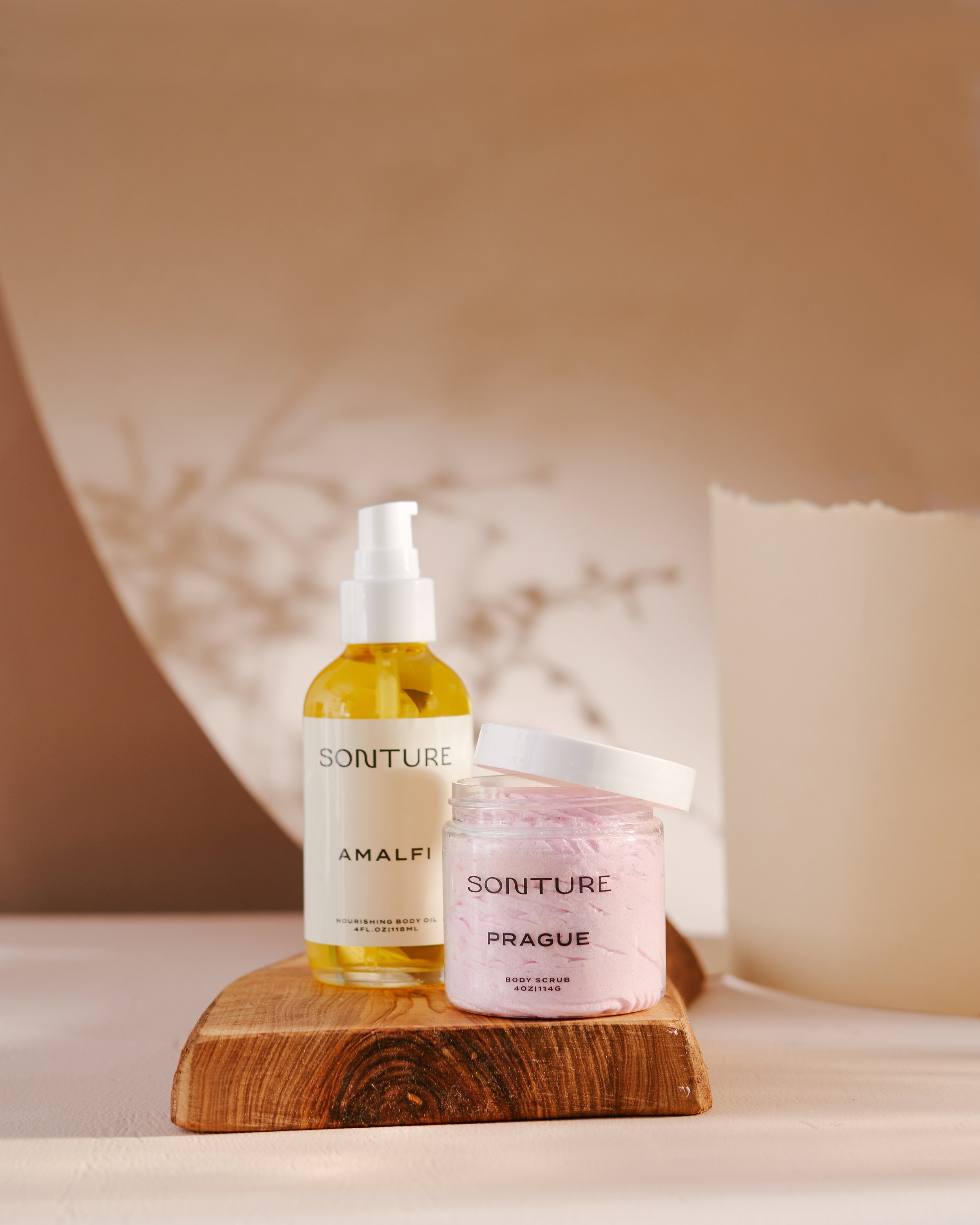 Sonture Beauty bath and body products photographed by Philadelphia photographer Tina Crespo, showcasing body oil and body scrub on wood.