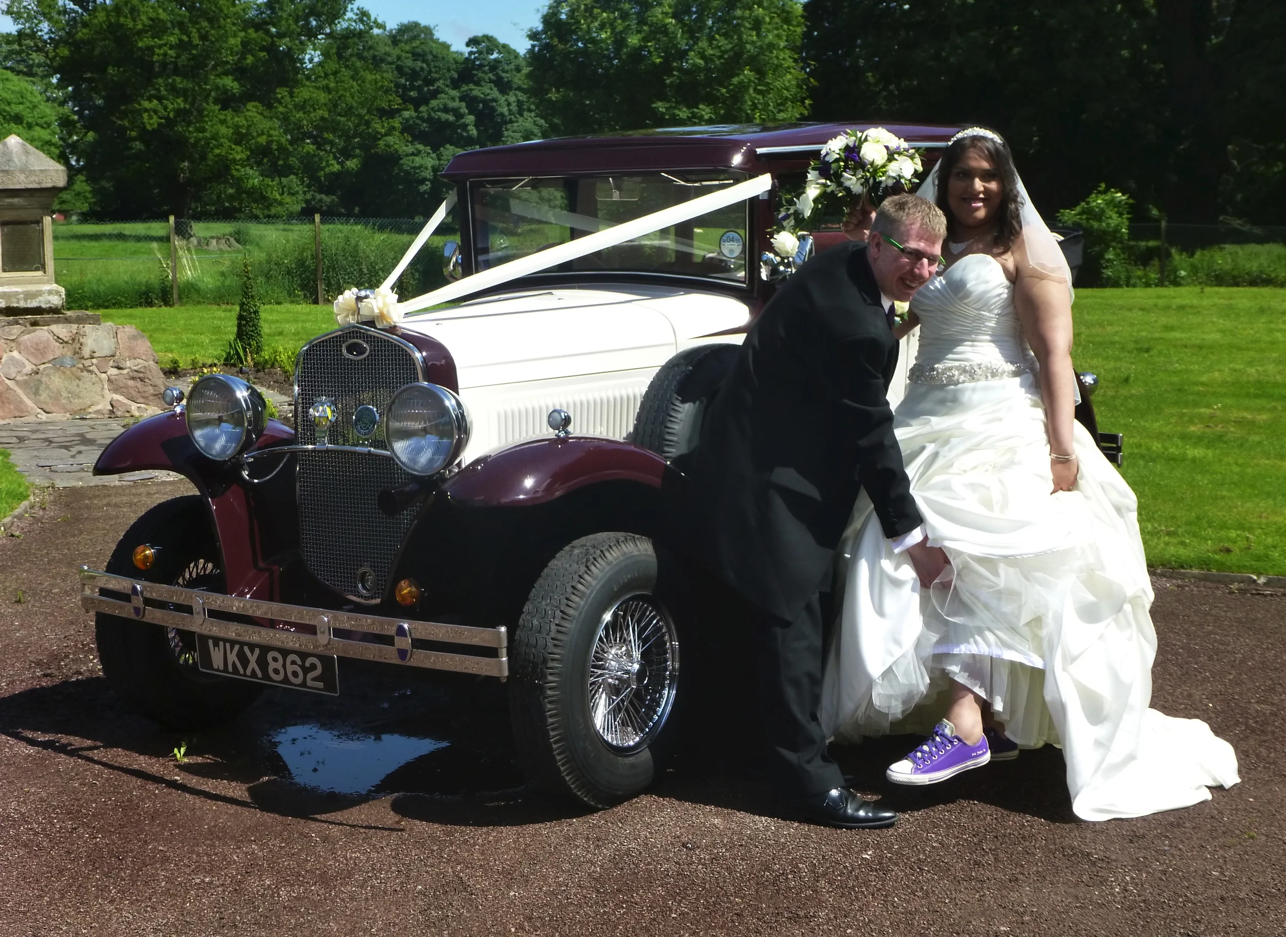 Louise & Martin enjoying their "fun" wedding. We get to see many different versions of footwear as the Bride exits the car. Louise was proud to display her comfortable trainers - matching the bridesmaids dresses. The puddle under the car is not a leak. The remains of the mornings downpour!