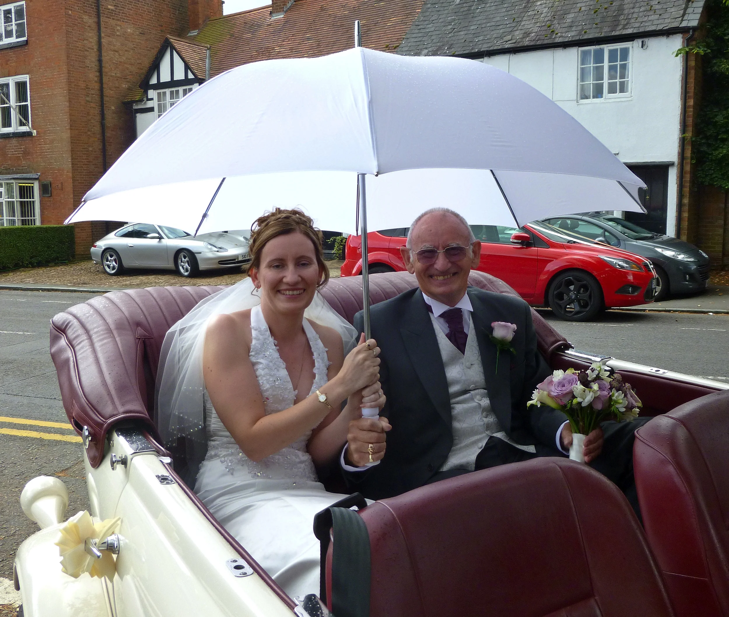 Sharon and Father enjoying the umbrella "fun" on arrival at St. Catherine's Church, Burbage for Sharon's marriage to Mark.