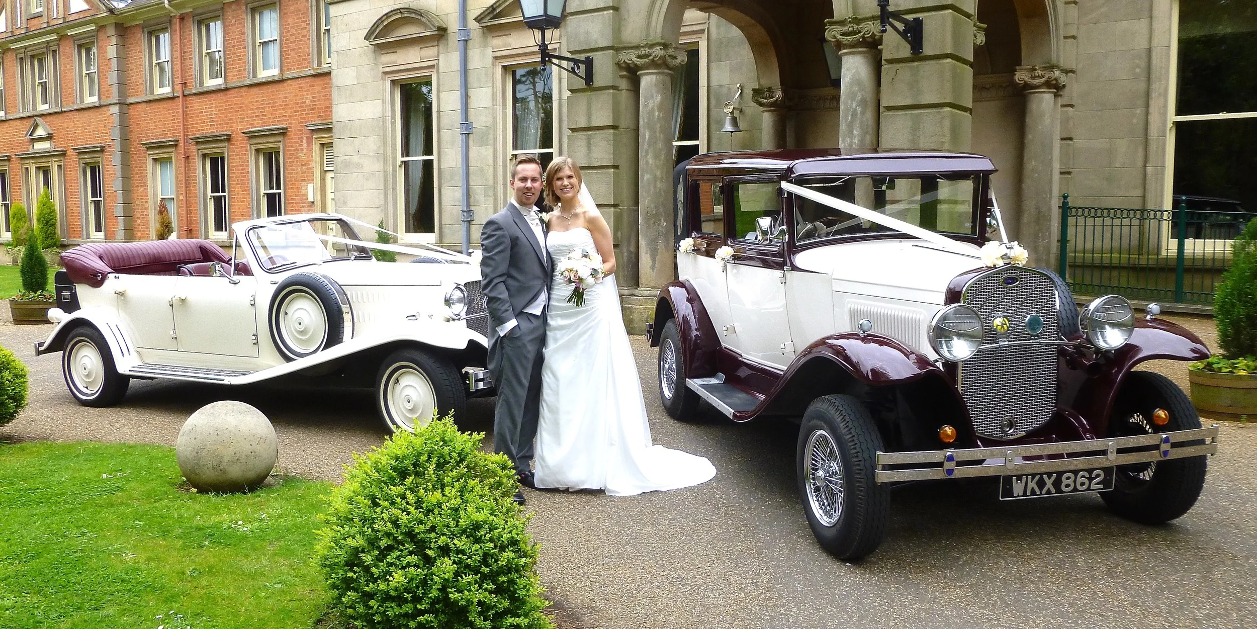 Amy and Mark oblige for a photo with the cars prior to a champagne reception with their guests at Kilworth House Hotel Lutterworth