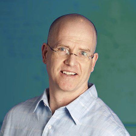 Portrait of a man with glasses wearing a light blue shirt.