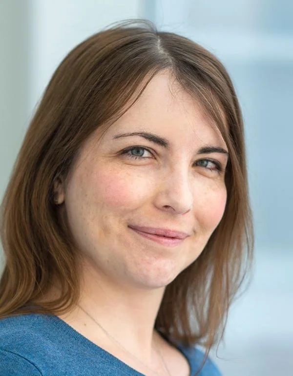 Portrait of a woman with brown hair wearing a blue shirt.