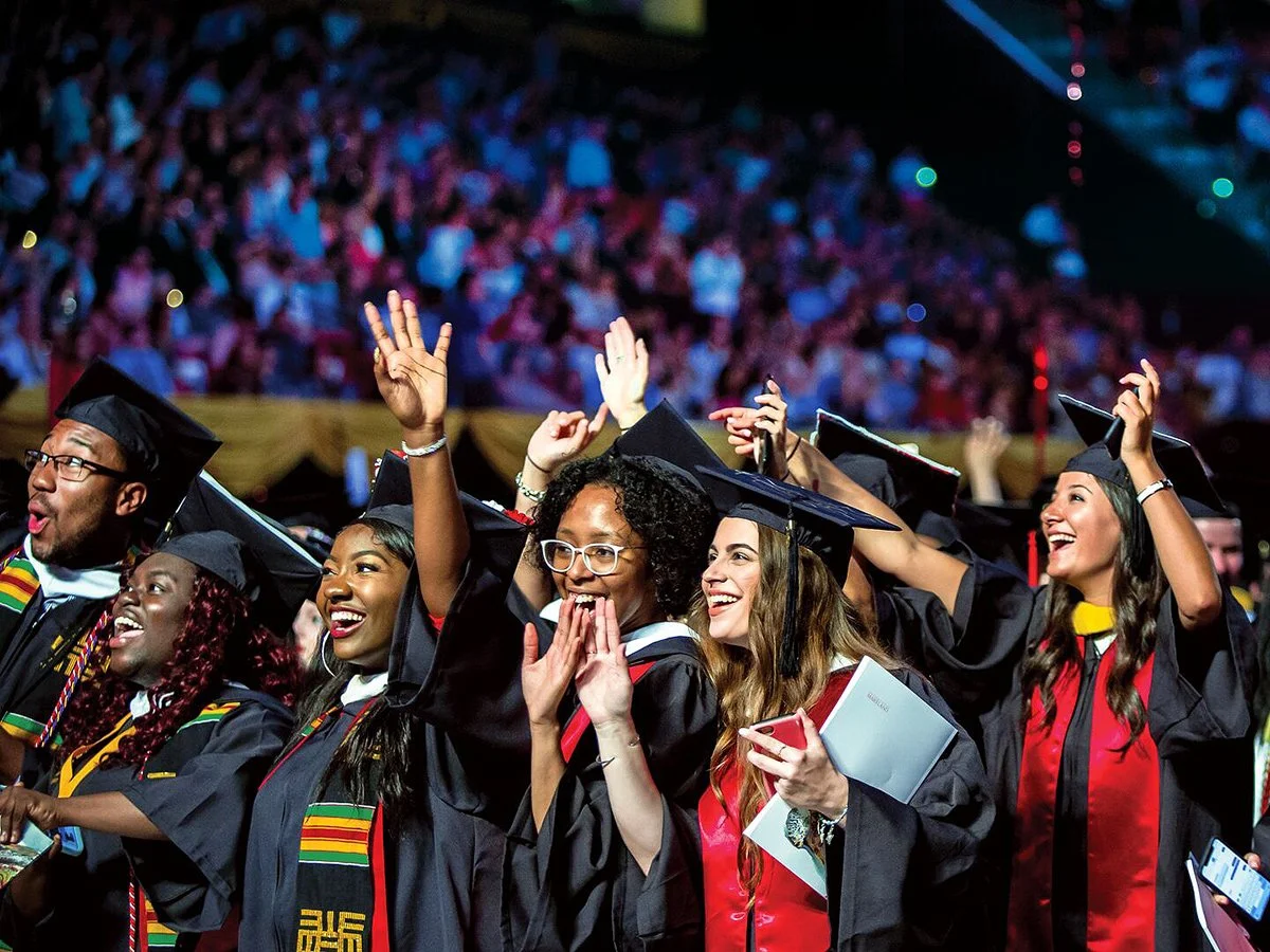 Several UMD graduates smiling at CMNS Commencement.