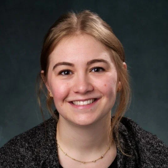 Portrait of a woman with blonde hair wearing a dark sweater.