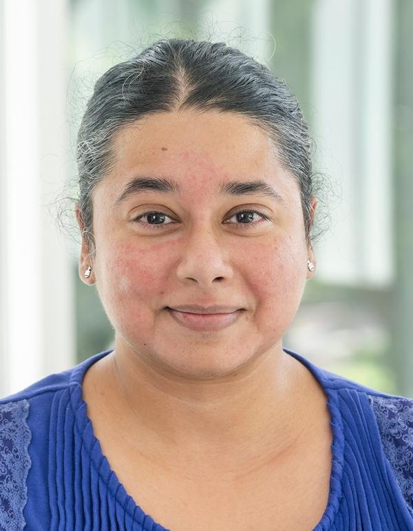 Portrait of a woman with dark gray hair wearing a blue shirt.