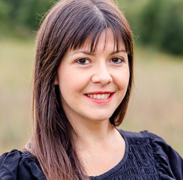 Portrait of a woman with brown hair wearing a black shirt.