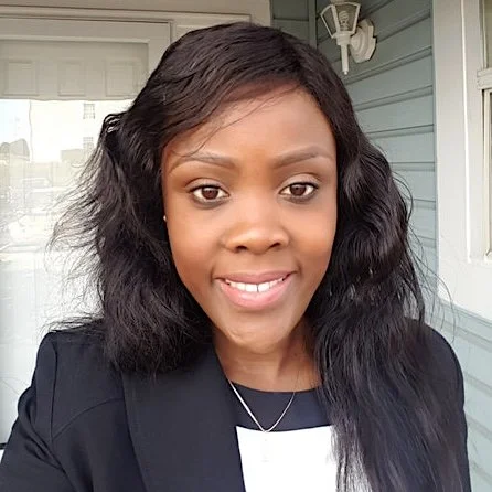 Portrait of a woman with dark hair and is wearing a black blazer.
