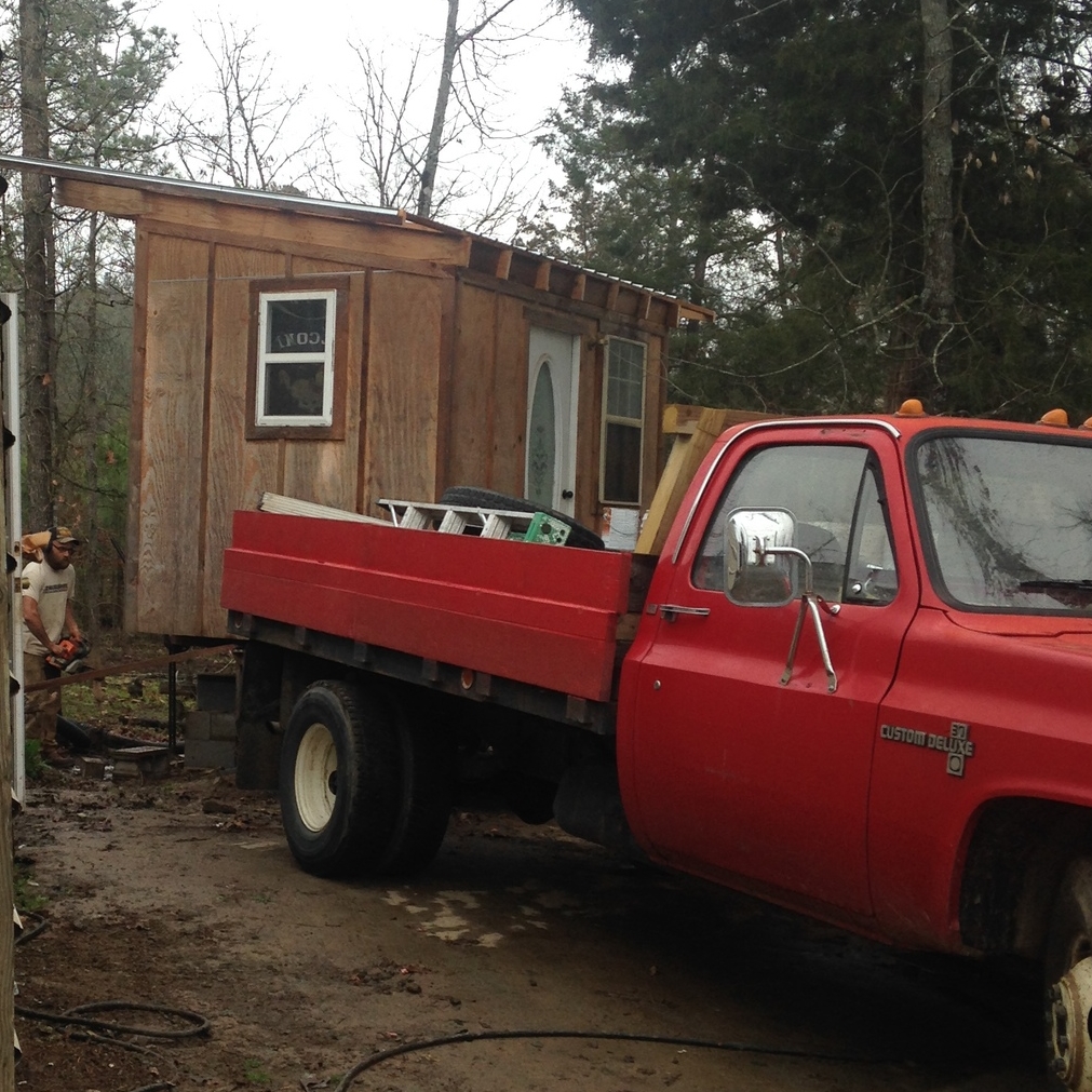 Travis carefully lowers the intern cabin onto the trailer for towing to the new farm.