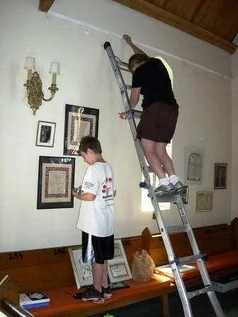 Ari Zanger takes time out from bar mitzah studies to help Cantor Marlena hang the exhibit.jpg