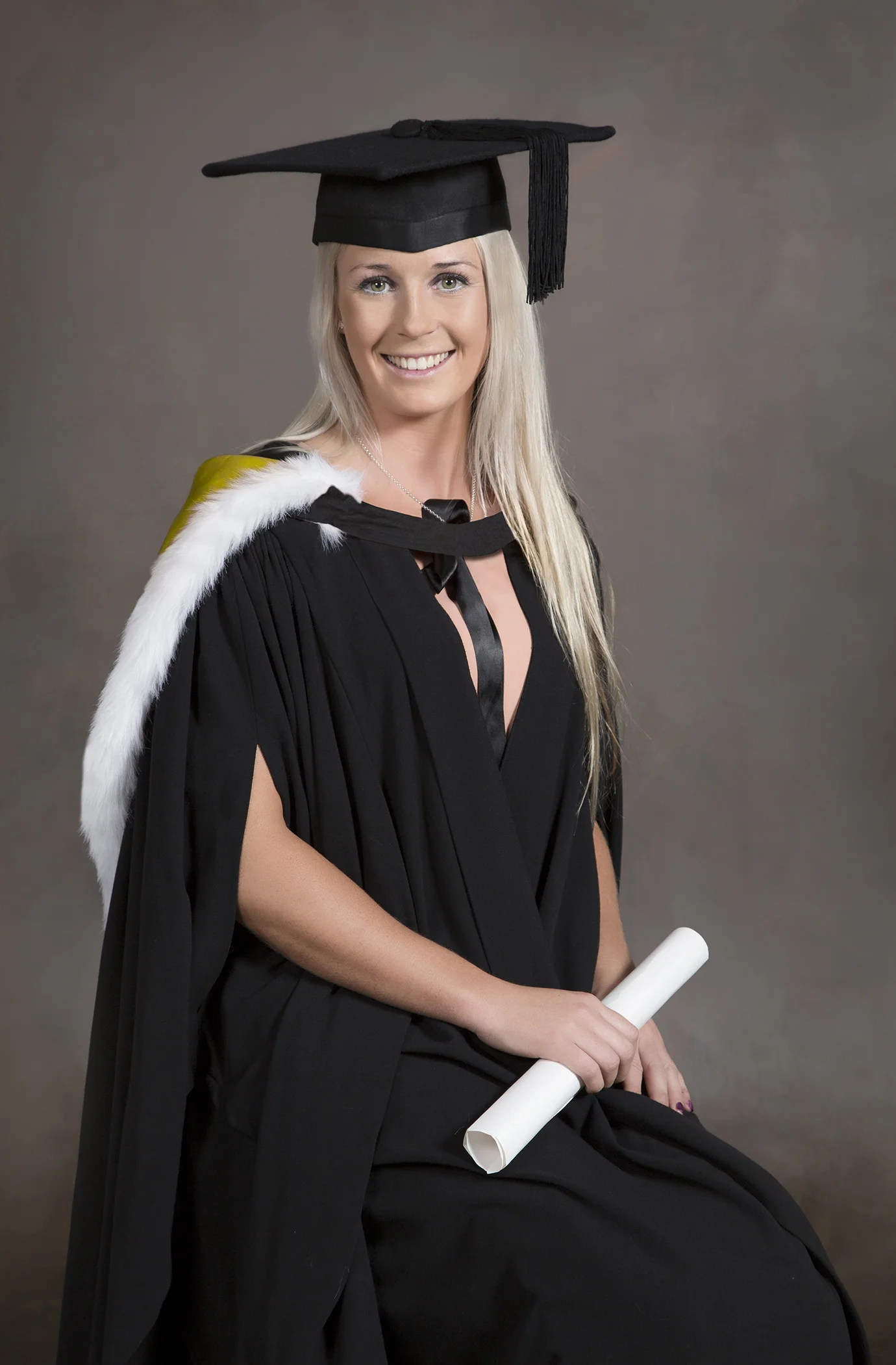 Dress: hat level with ground, fringe hidden, V 10cm down from neck, hood off right shoulder with colour showing. Hold scroll half way along. NB: could do with showing a little more hood/colour on right shoulder.