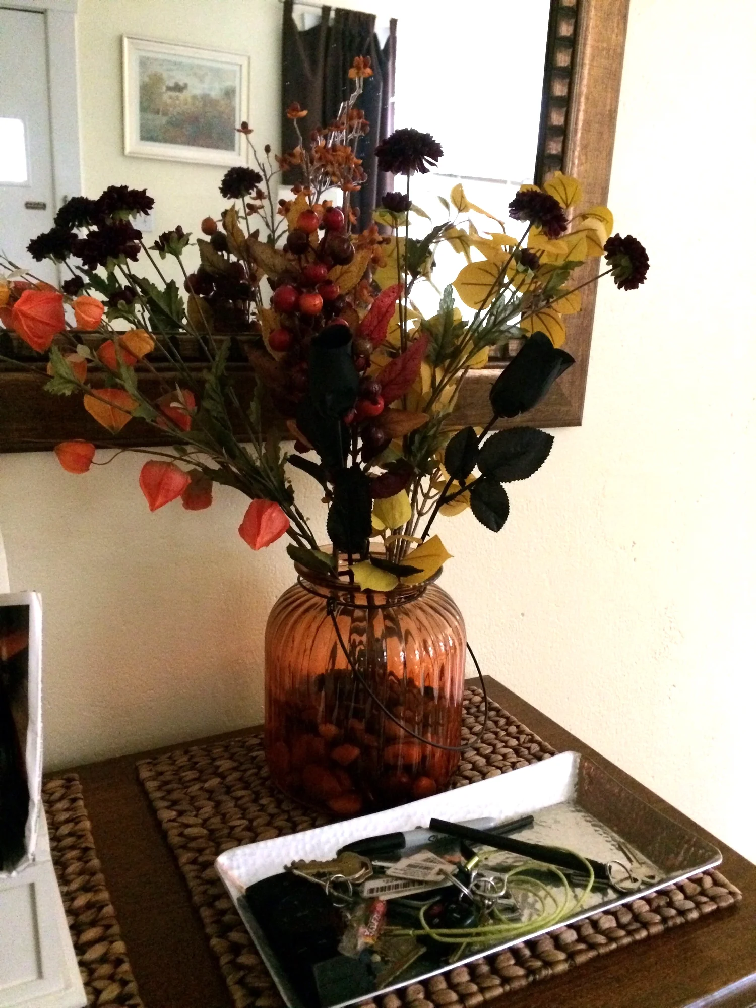 Black roses join other faux fall floral on the entry console for a no-mess arrangement
