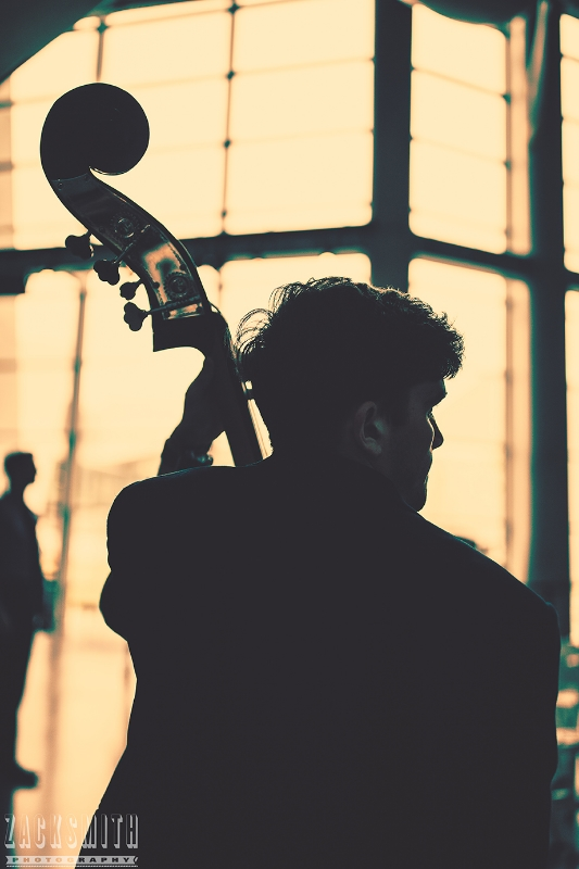 A Bass player for the Tulane Marching Band is silhouetted at the WWII Museum.