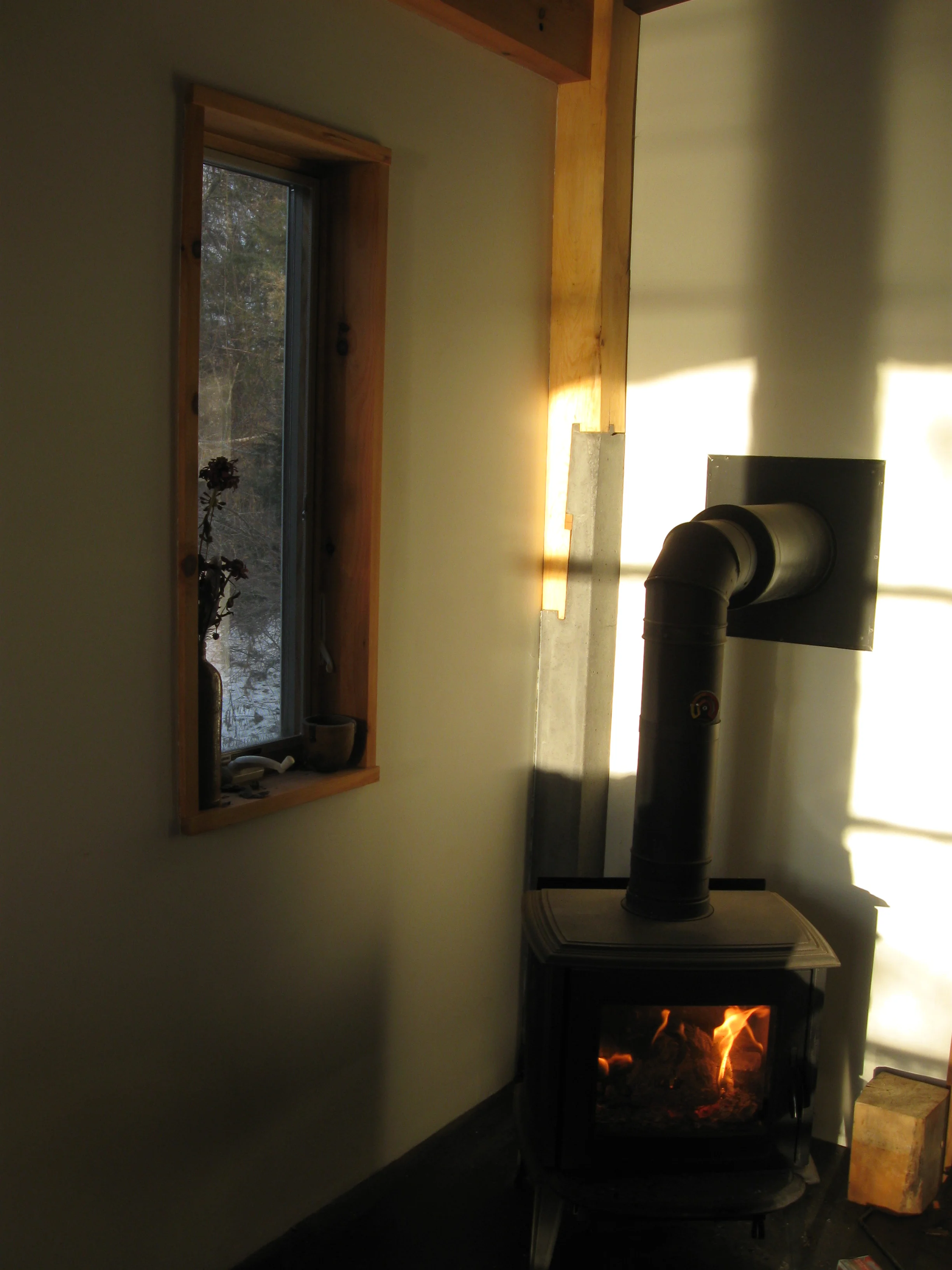  Minimal window treatments display&nbsp;the wall thickness without adding further weight. While a&nbsp;handsome morso stove fires away, and&nbsp;the post&nbsp;behind it transitions at the joint&nbsp;to concrete. 