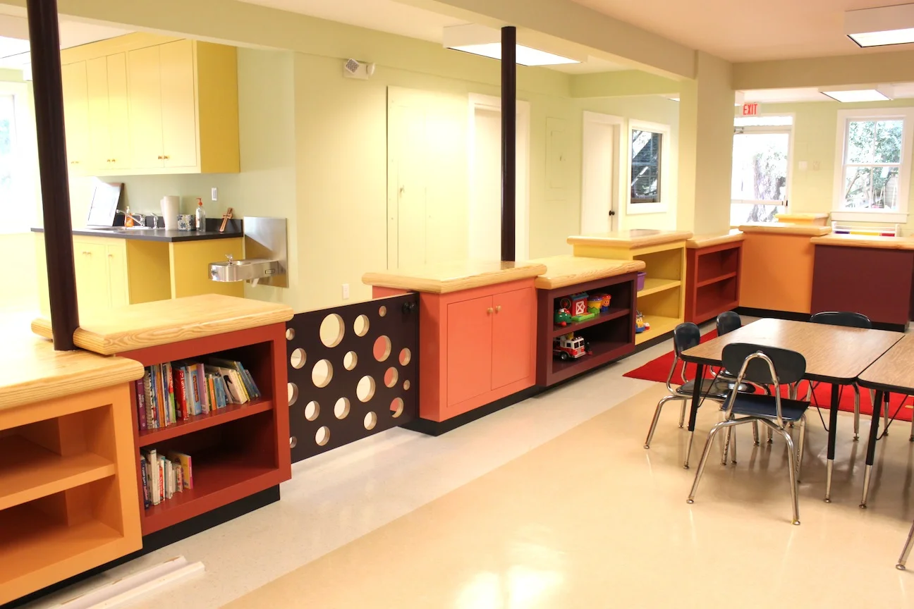  A complete revisioning of an existing schoolhouse constructed in 1962. The renovation eliminated most of the interior walls to create a brighter and more flexible space. Custom cabinetry finished in warm hues serves as toy and game storage and as sp