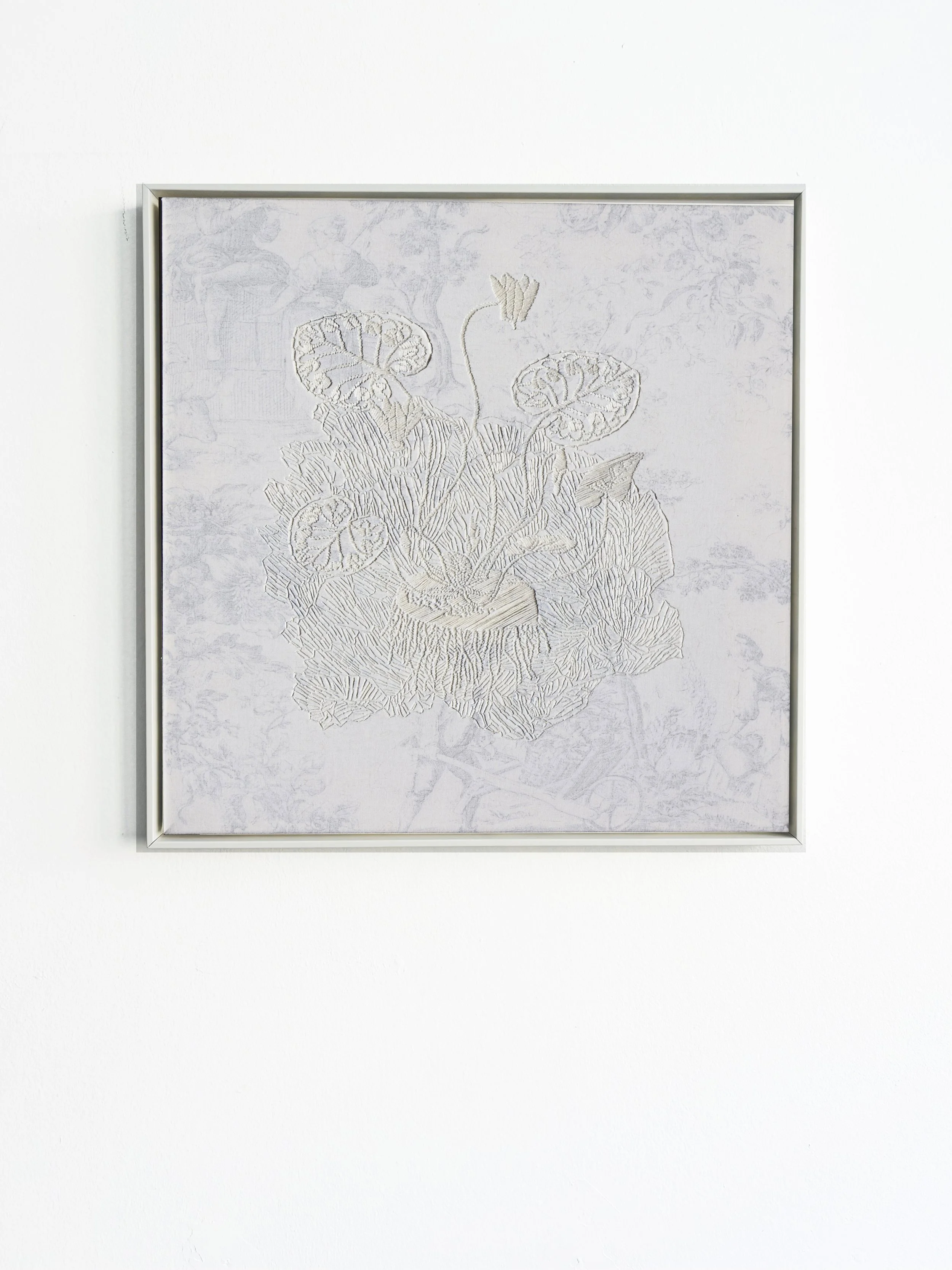 Ein weißes Rahmenbild mit einem abstrakten Lotusblumen-Design in hellen Tönen an einer weißen Wand.