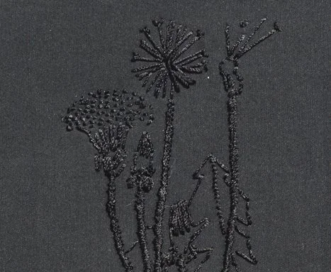 Handgefertigte Perlenstickerei von Blumen auf schwarzem Hintergrund.