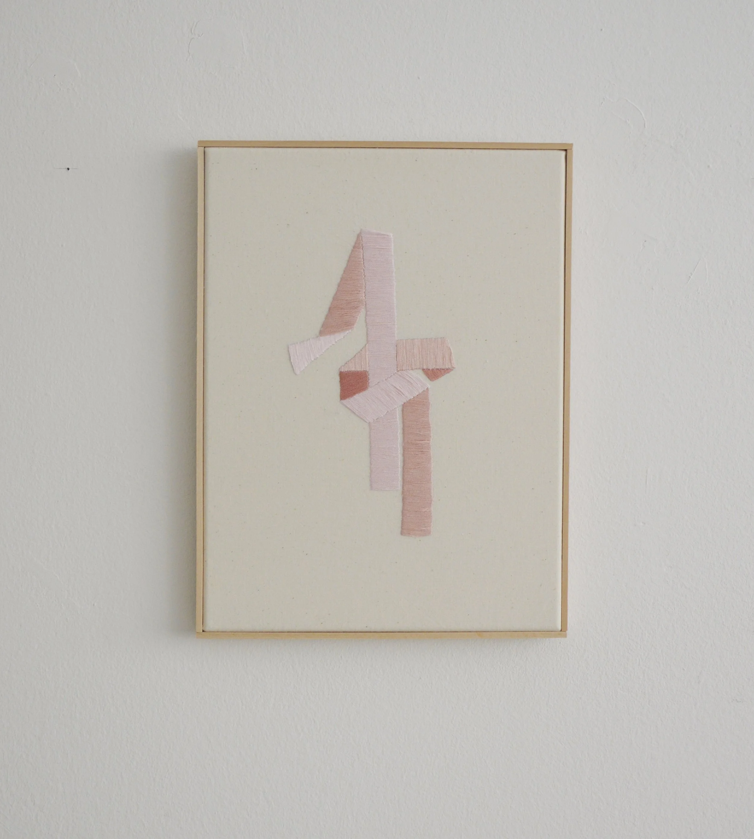 Kunstwerk mit einer abstrakten 3D-Form aus Stoff auf einem weißen Hintergrund in einem Holzrahmen