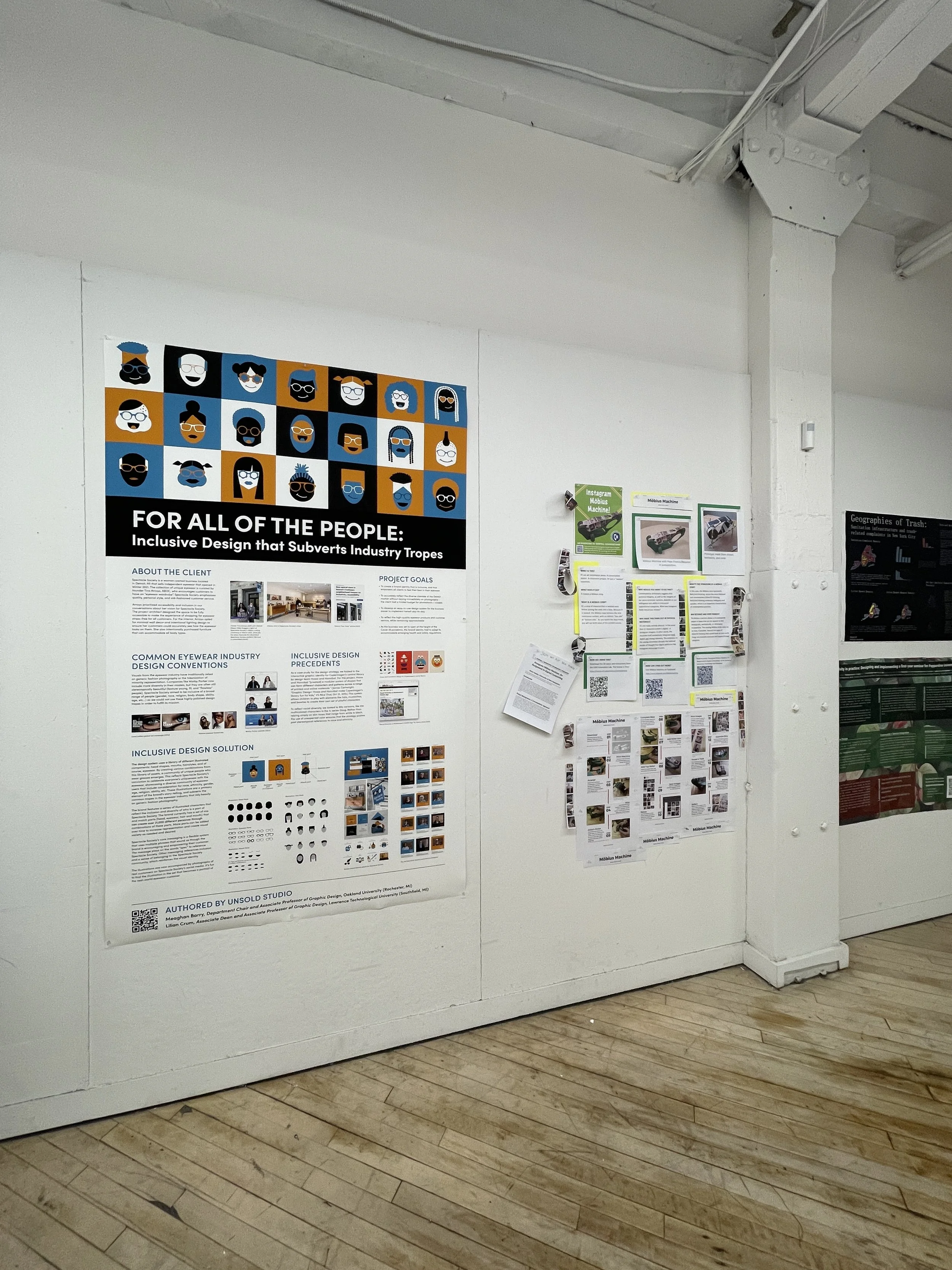 School or project display board with posters and papers pinned on a white wall.