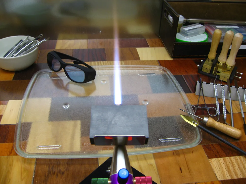 Always wear protective didymium glasses. My pair is pictured to the left of the flame. It's of the "fit over glasses" variety. Note the purple/blue tint to the lenses. These safety glasses protect your eyes from bright yellow sodium flare and UV light.