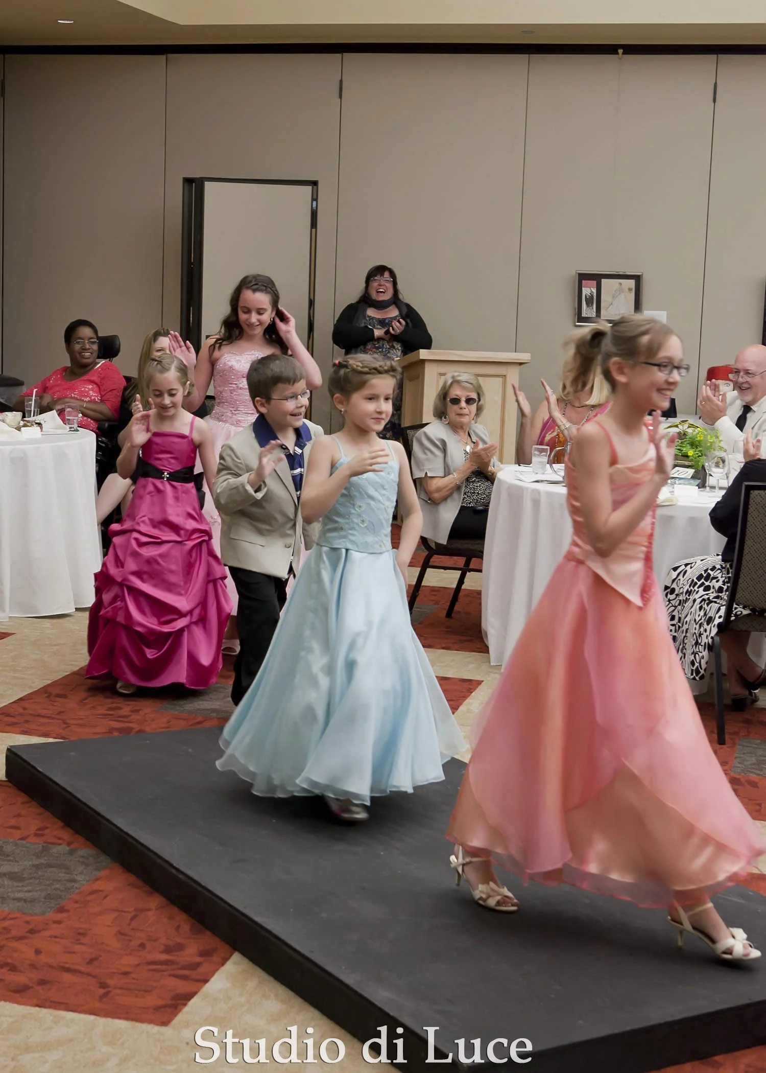 The child models take one last turn down the runway.
