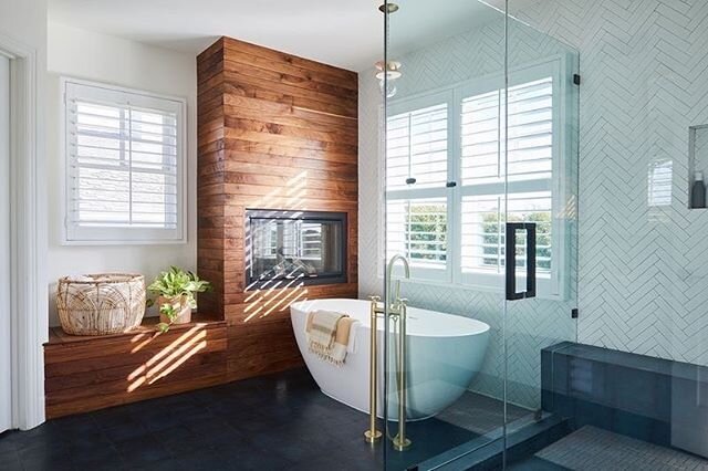 &bull; The fireplace and bench in wood created a statement wall, but also added warmth and coziness to this bathroom 🛁 The dated and clunky jacuzzi tub was replaced with a modern and streamlined soaking tub which opened up the space + by removing th