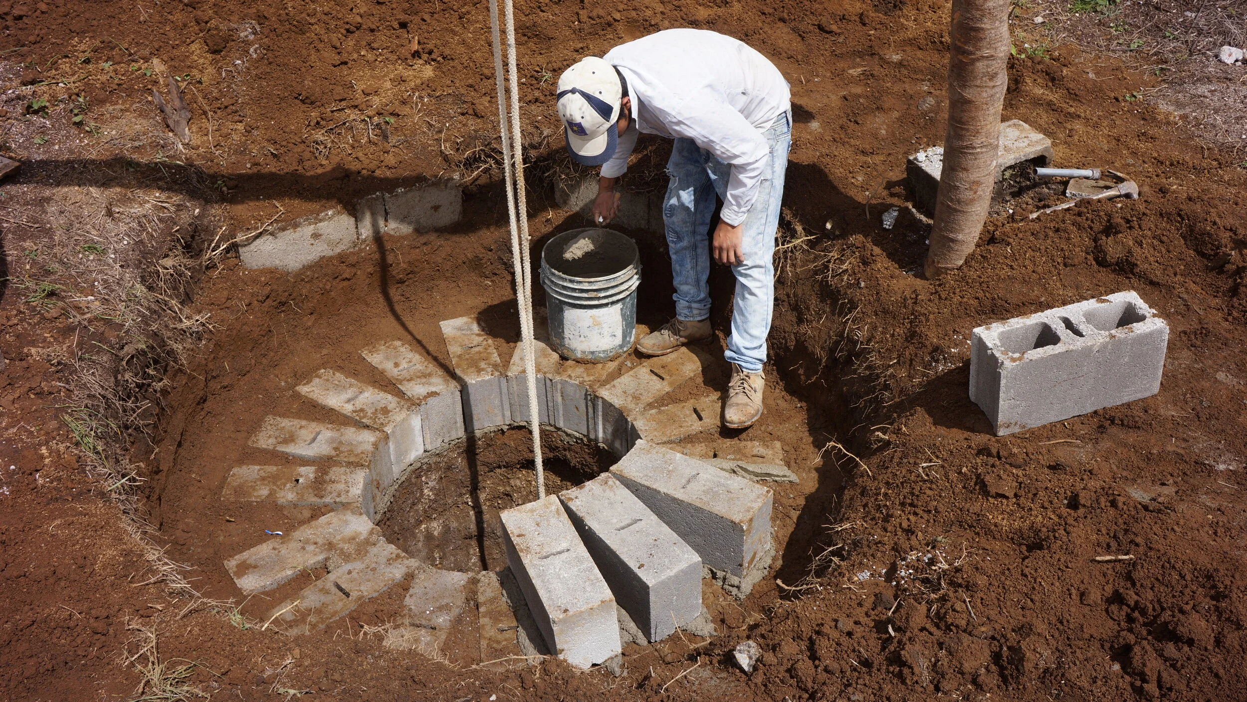 One of the workers lays concrete blocks beforehand so the ground doesn’t cave in
