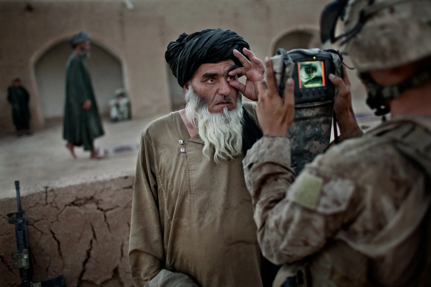 A U.S. Marine records the biometric data of an Afghan villager at a mosque in Marja District, Helmand Province, Afghanistan.
