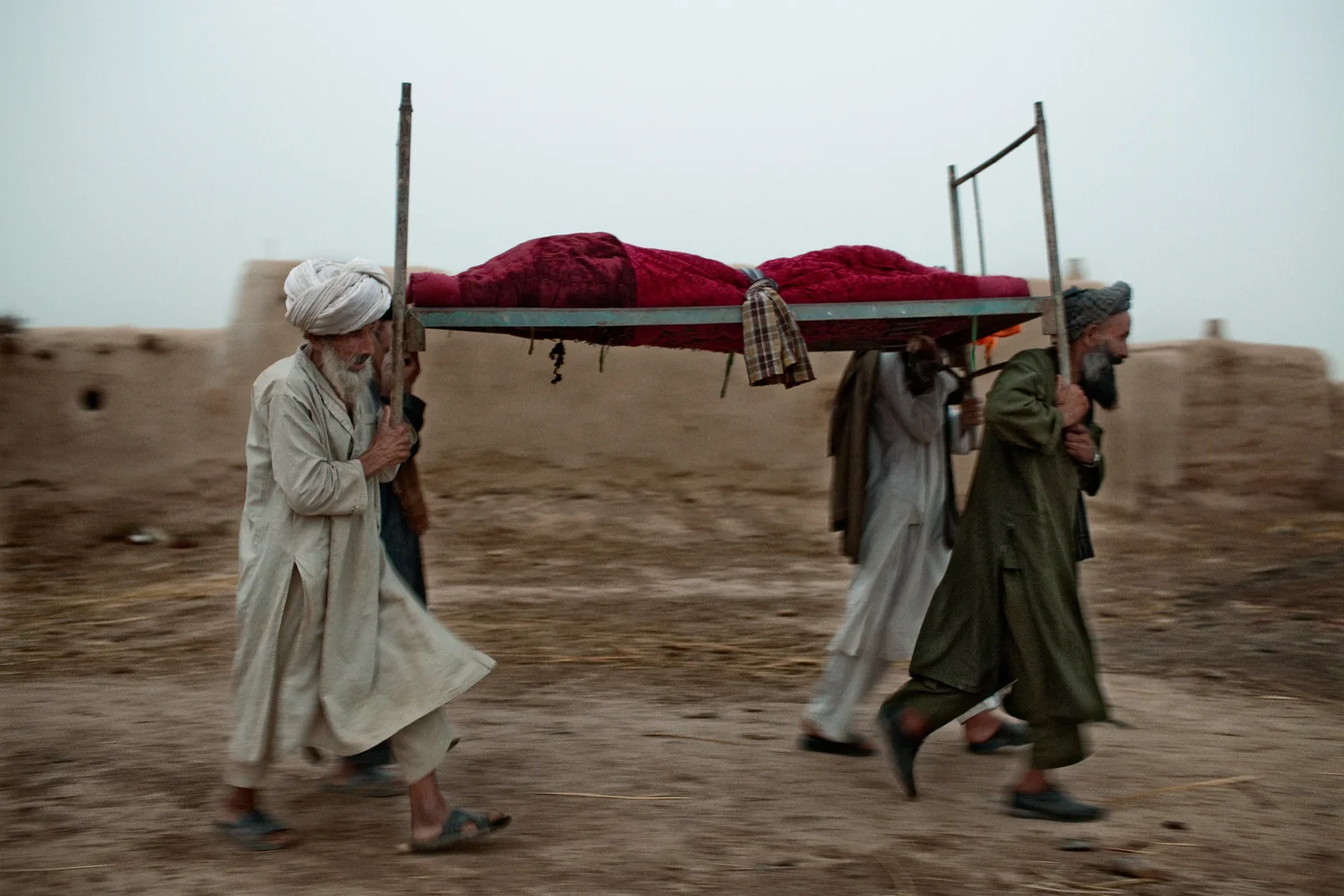 Family members of Gulmakay, a fourteen-year old Afghan girl killed by a U.S. Marines mortar strike, carry her body after presenting it to Marines in Abdullah Jan Village, Marja District, Helmand Province, Afghanistan.