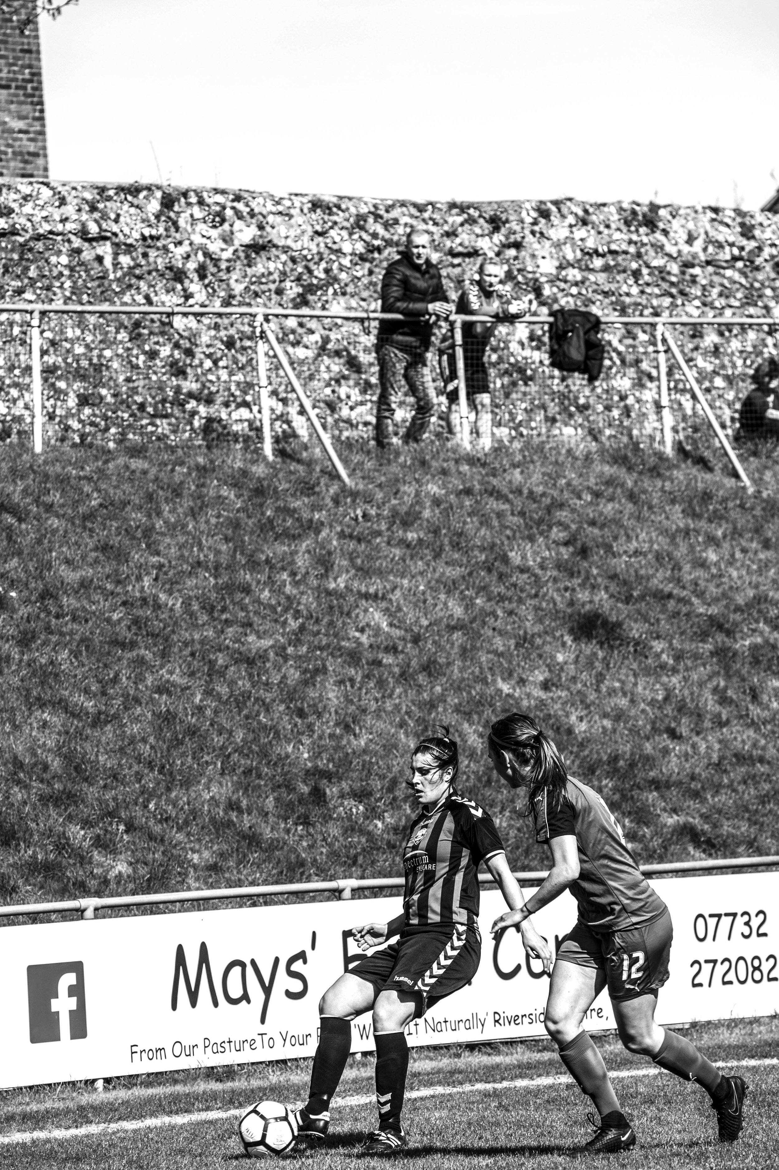 Women footballers with spectators.jpg