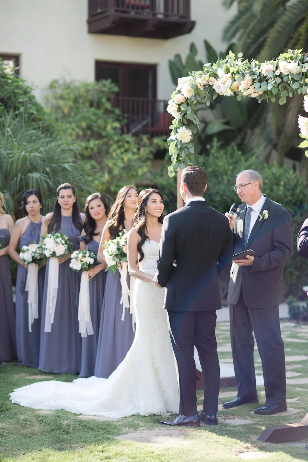 Wood arch with garland wedding ceremony at Estancia Hotel & Spa, La Jolla by Compass Floral.