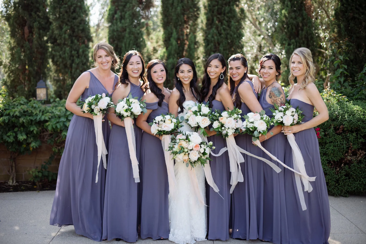 Purple bridesmaids with neutral bouquets by Compass Floral | Estancia Hotel & Spa, La Jolla