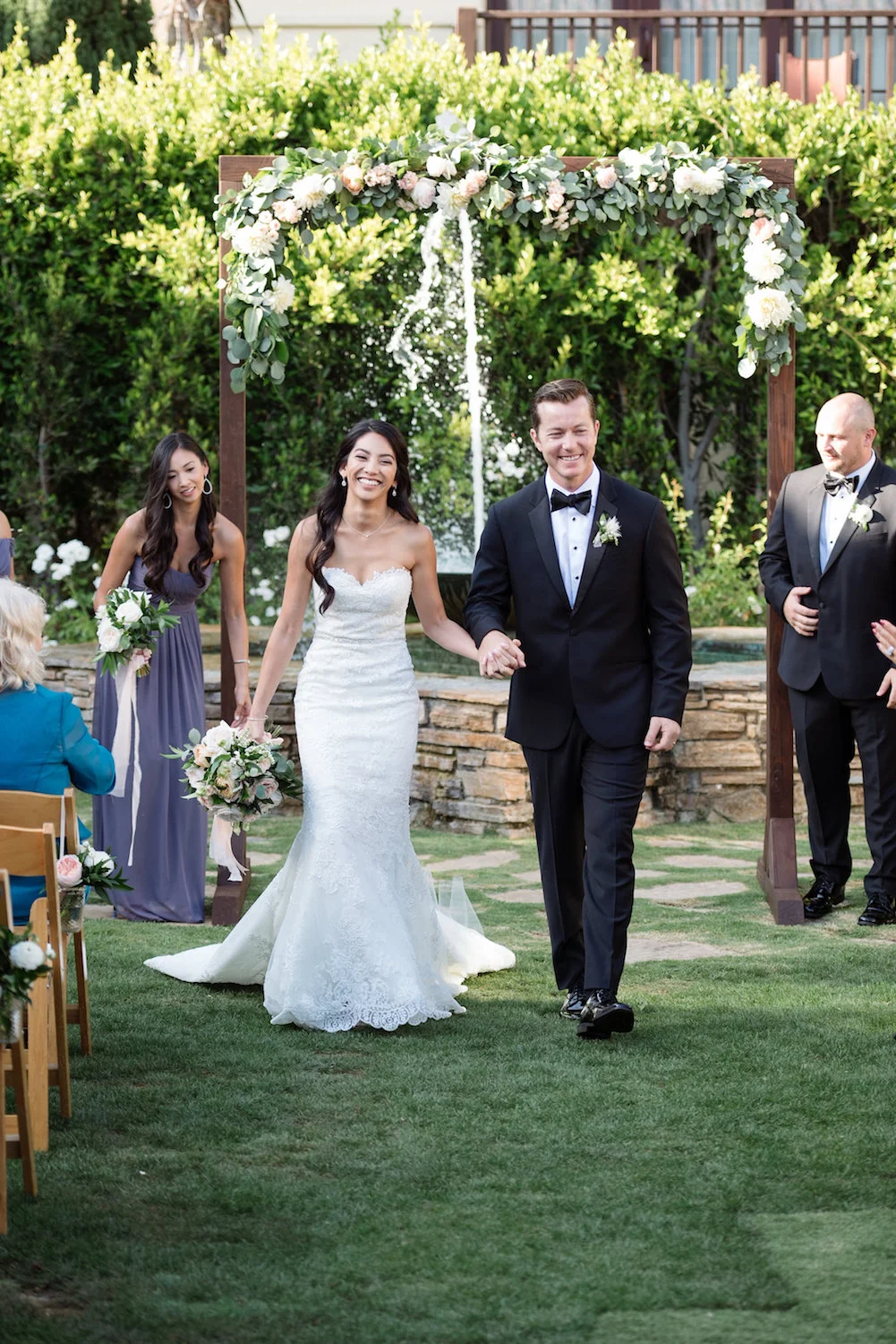 Wood arch with floral garland by Compass Floral | Estancia Hotel & Spa, La Jolla