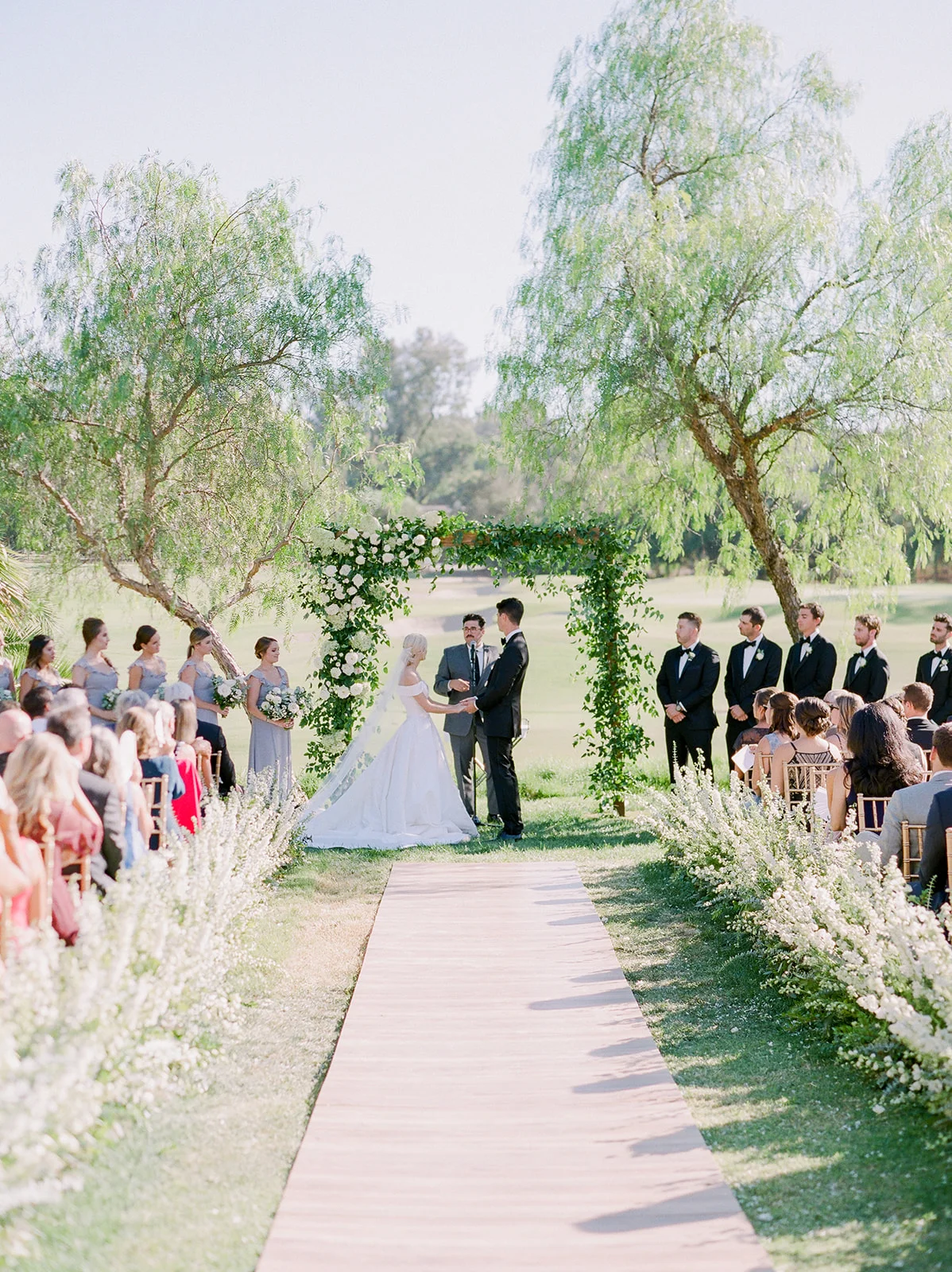 Flower lined aisle with greenery covered arch, outdoor ceremony | Rancho Santa Fe Golf Club | Compass Floral | Wedding Florist in San Diego and Southern California | Rachael McCall Photography