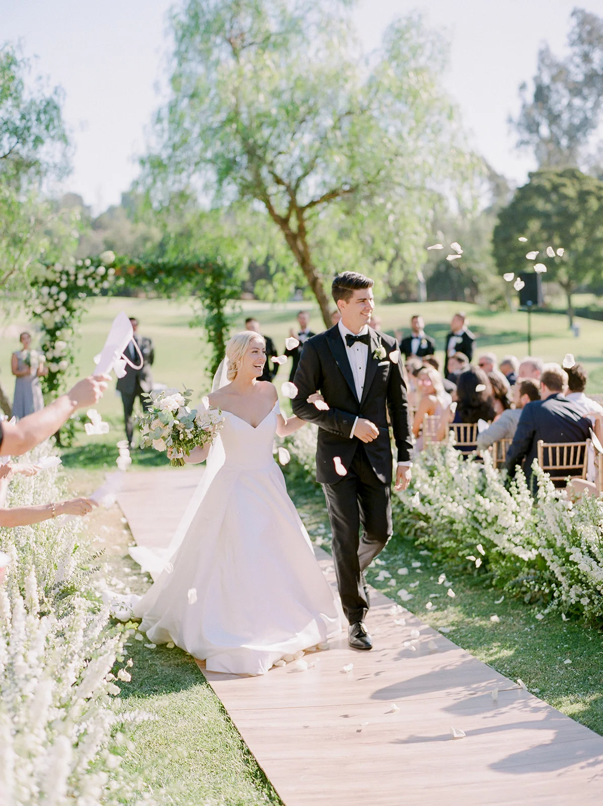 Bride and groom walk down flower lined aisle | Rancho Santa Fe Golf Club | Compass Floral | Wedding Florist in San Diego and Southern California | Rachael McCall Photography