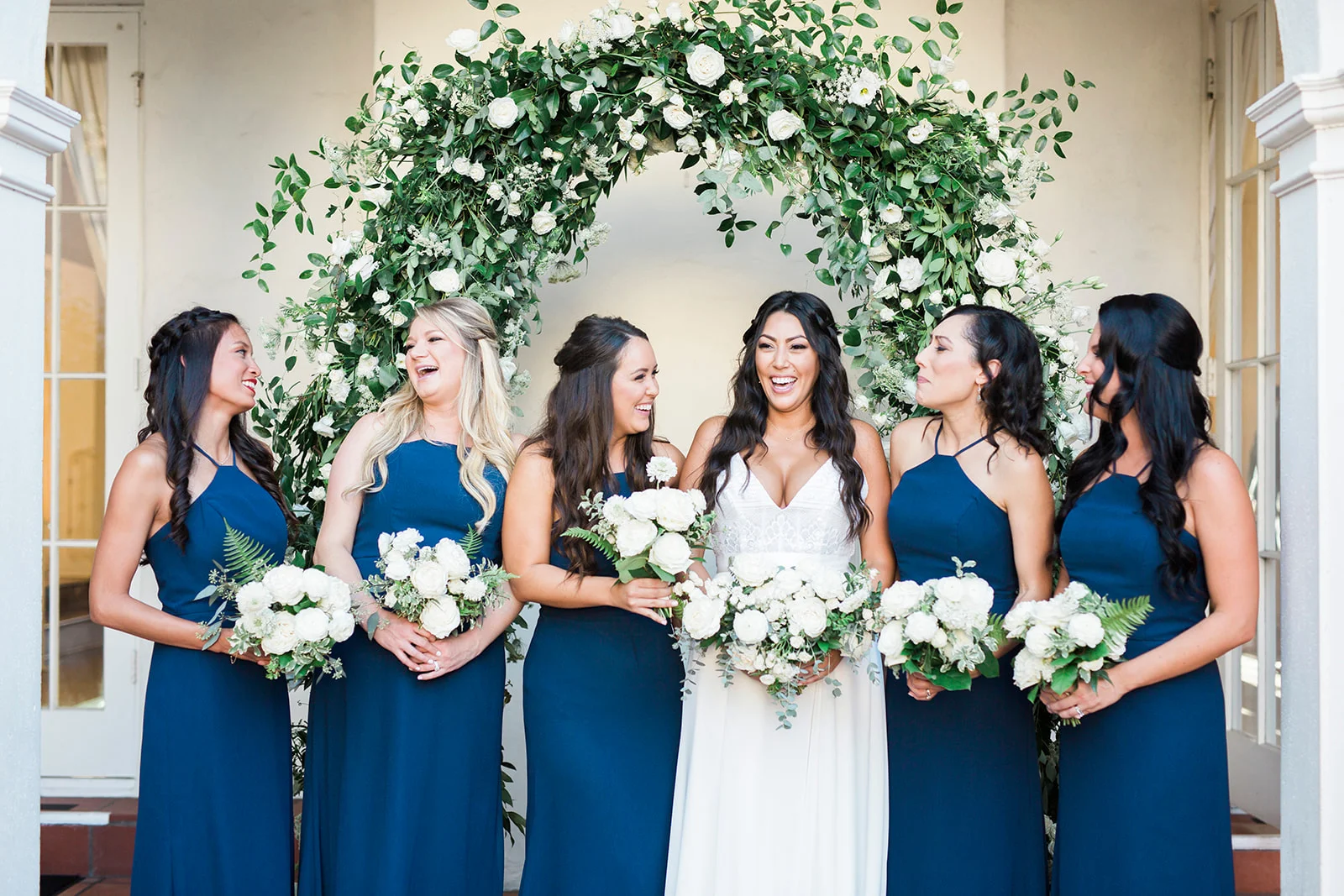 Bridesmaids in blue, white bouquets, elegant greenery arch | Darlington House, La Jolla | Compass Floral | Wedding Florist in San Diego and Southern California | My Sun and Stars Co. Photography
