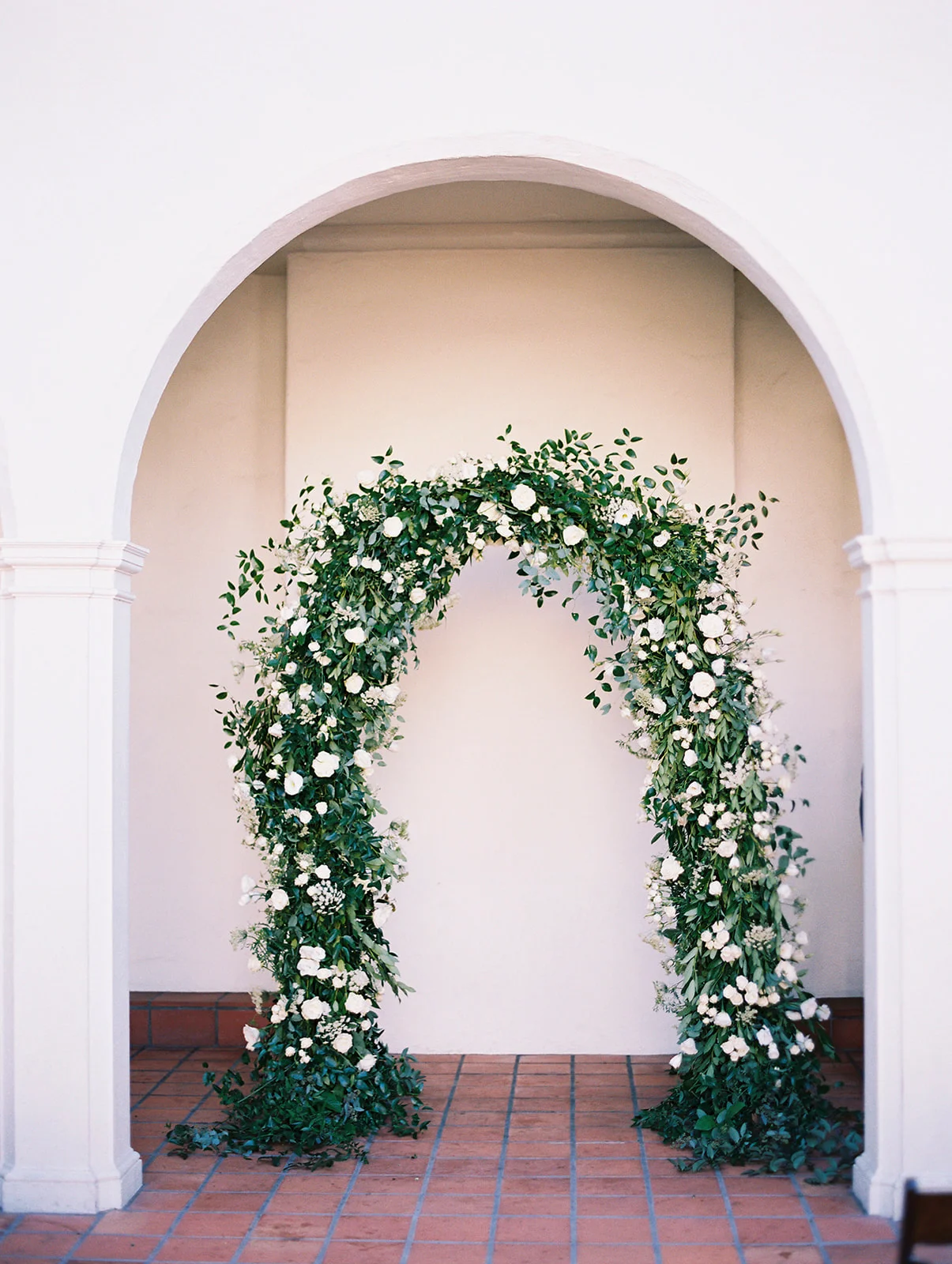 White flowers and smilax covered rounded wedding ceremony arch | Darlington House, La Jolla | Compass Floral | Wedding Florist in San Diego and Southern California | My Sun and Stars Co. Photography