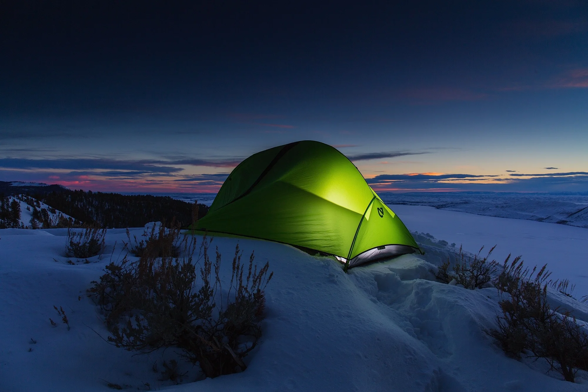 Lit Nemo tent at dusk. Winter camping above Fremont Lake in Bridger Teton National Forest