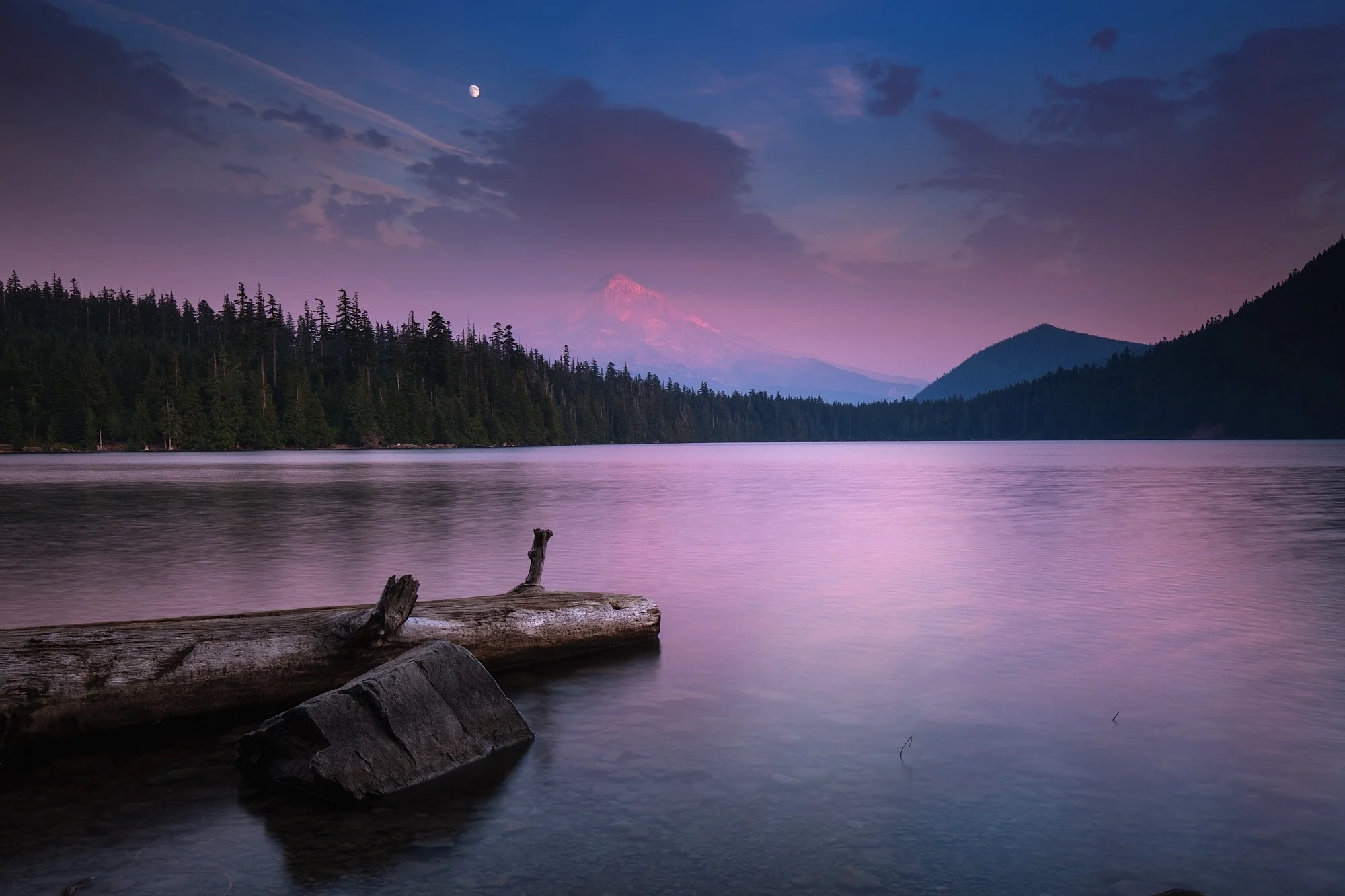 A full moon rises over Mount Hood at dusk from Lost Lake