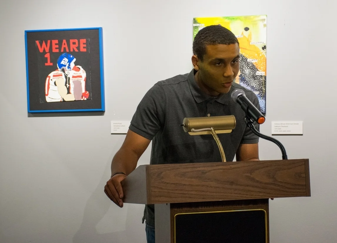 Johnathon Callum, who recently graduated from PBHS, speaks during the May 3 opening reception. HIs piece, "Brotherhood," seen to his left in the photo, "depicts the image of two interracial players coming together during a political conflict," Johnathon explained in his artist statement.