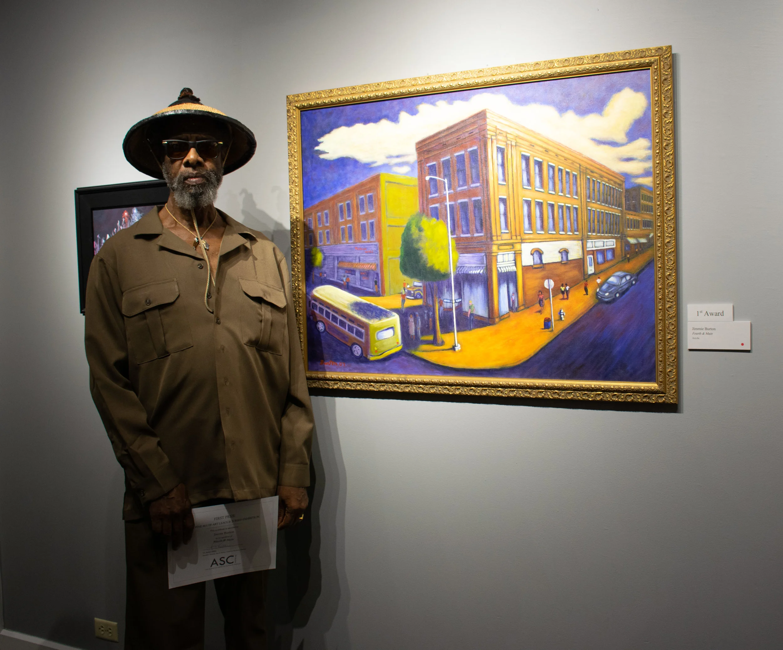 Jimmie L. Burton with his painting “Fourth & Main,” which won First Place.