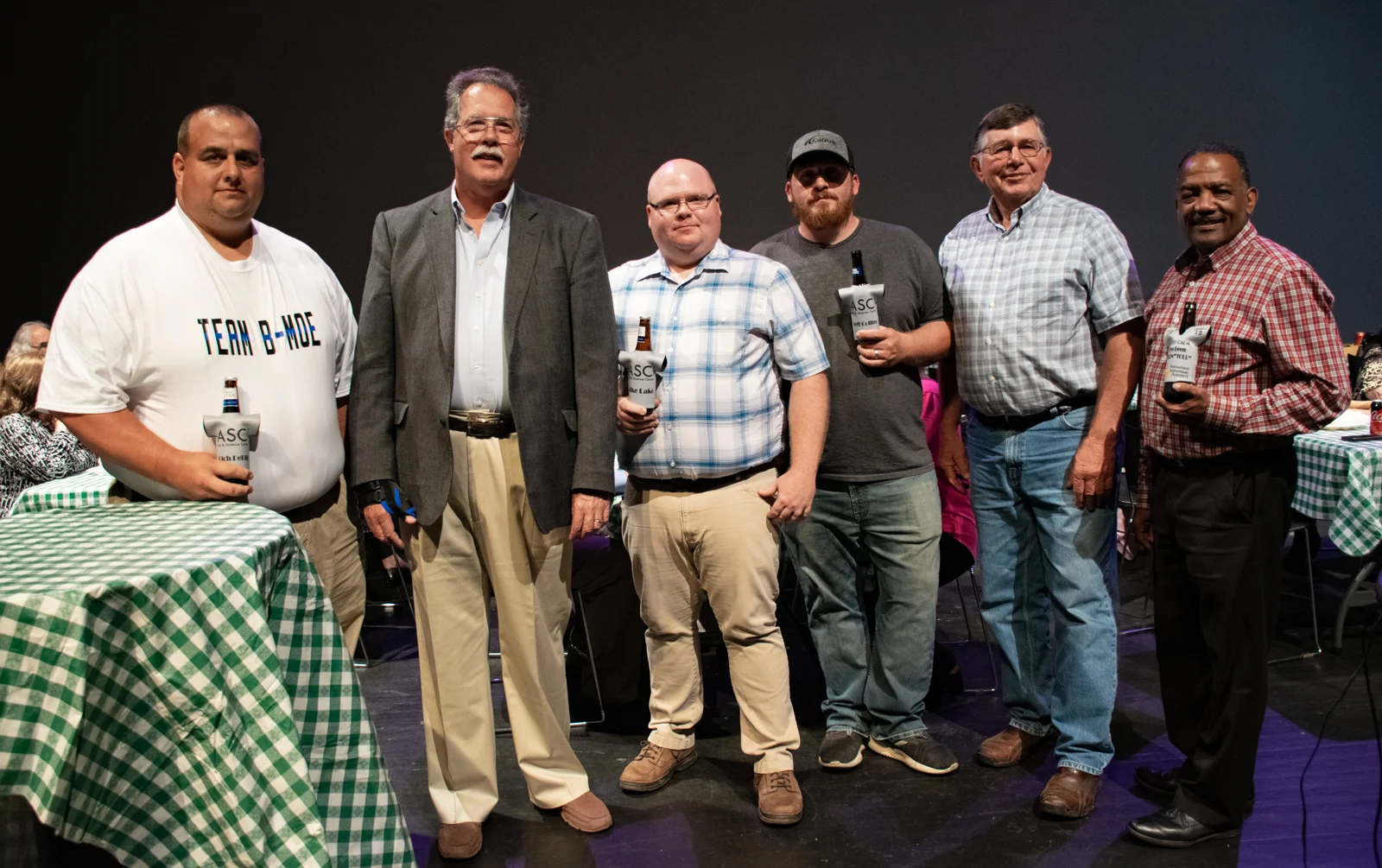 Rich DeBill (from left), Michael Healy, Mike Lake, Jeff Collins, Mike Kline, Kenny Fisher and Scottie Abernathy (not pictured) were honored “for their continued patience and willingness to be volunteered by their significant others for countless ASC events, productions, and programming” with awards dubbed “The Volun-Tolds.” The honorees received personalized beer “huggies” from NovelTs.