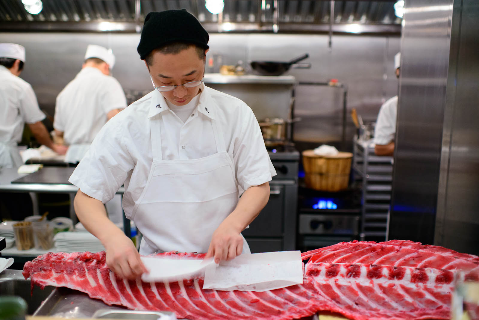 Chef Nick Kim removing excess moisture from the tuna