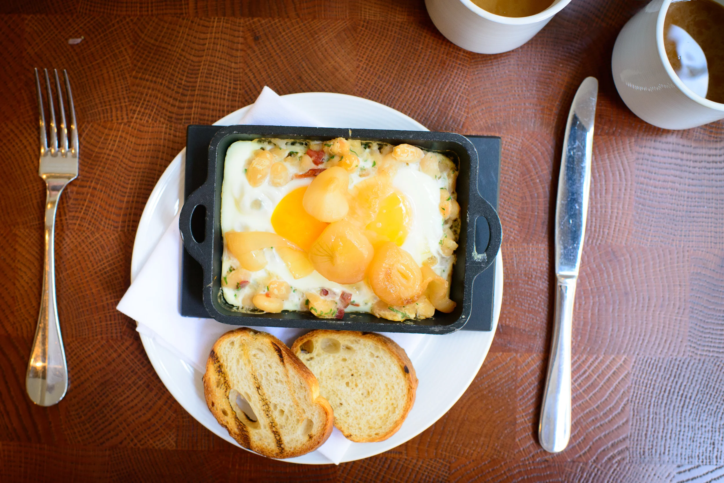 Baked eggs, cannellini beans, speck, smoked onions, grilled brea
