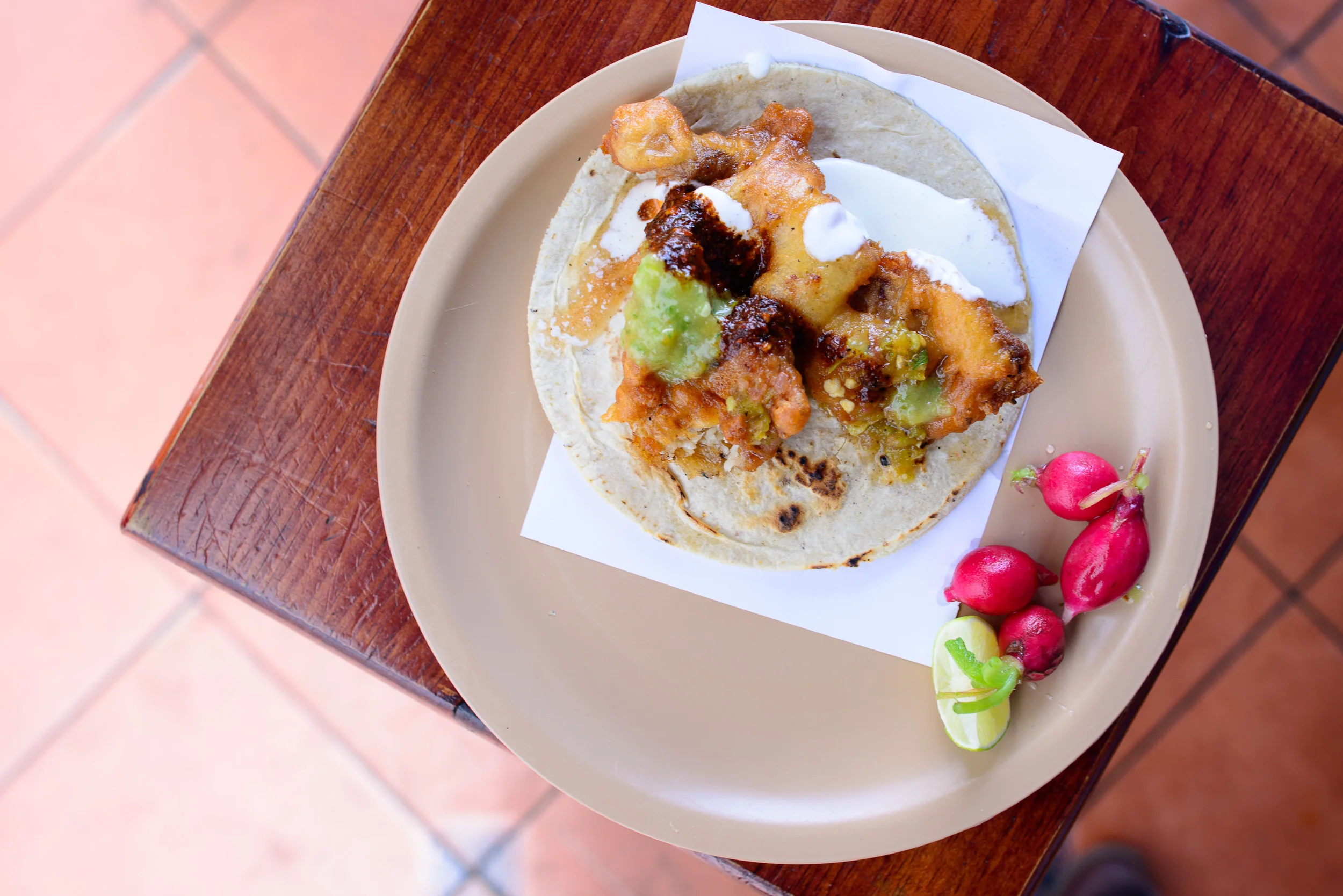 Taco de cazón con salsa verde, roja, rábano, y límon