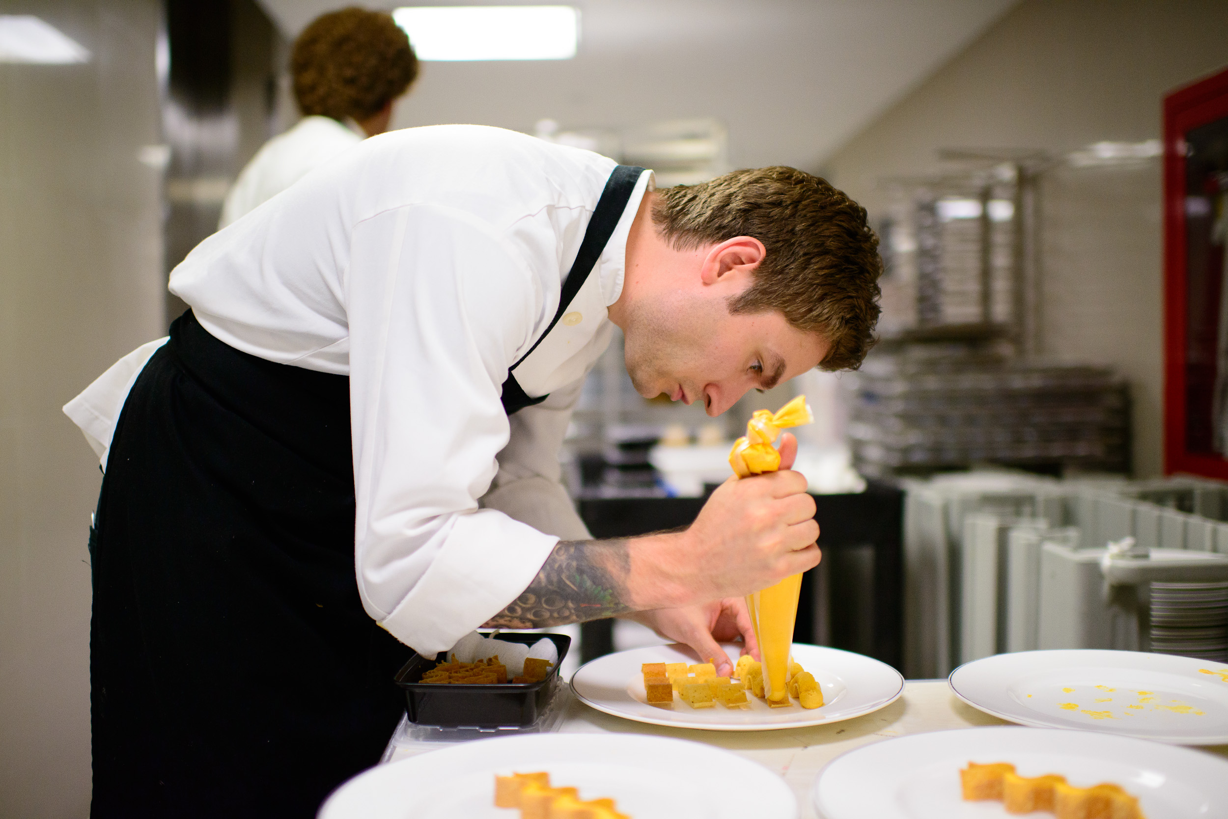 Alex Stupak piping sea urchin mousse into wavy masa crisps