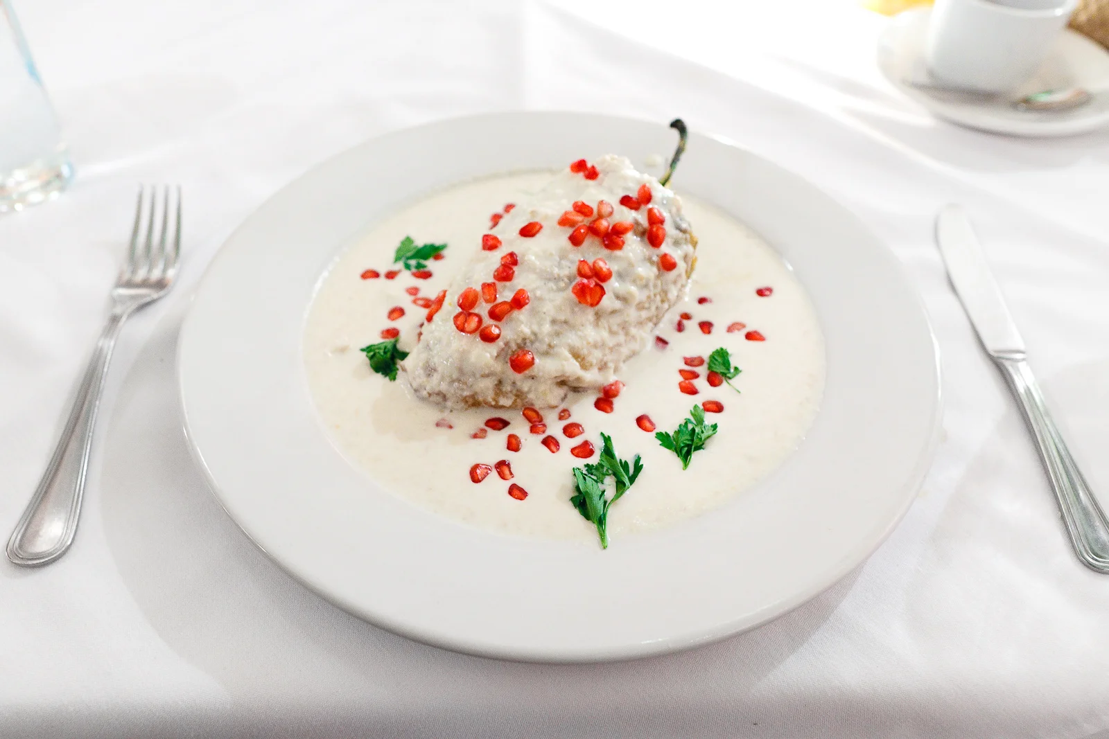 Chile en Nogada de Puebla (Poblano pepper stuffed with meat and fruits, walnut sauce, pomegranate)