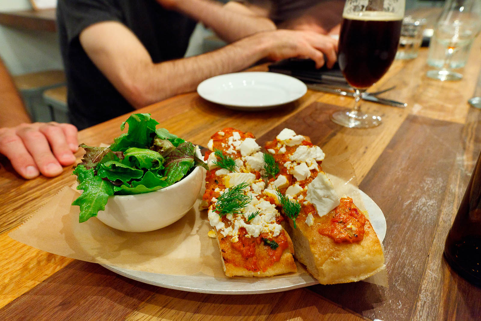 Arahovas Feta - Ajvar roasted red pepper spread and dill open-face on focaccia with green salad and olive vinaigrette ($10)