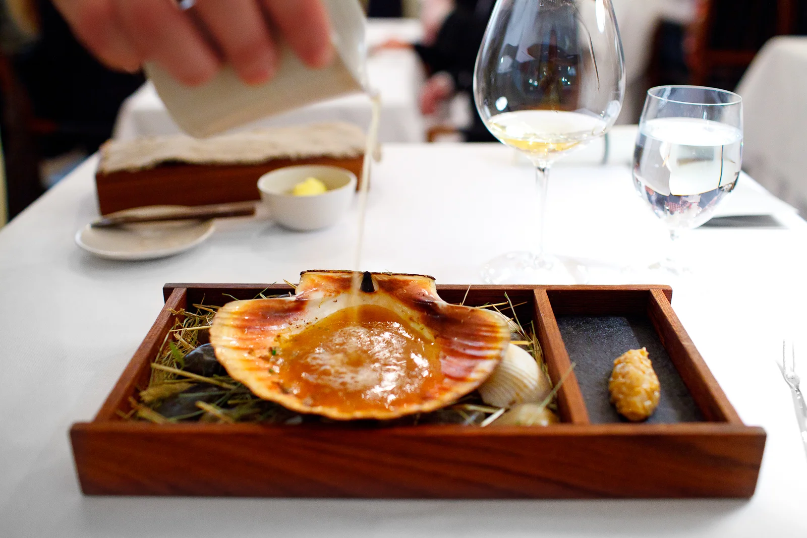 3rd Course: Scallop from Trondheim, Norway in two servings. Second, raw marinated and bound in confit of the roe with a bouillon of dried scallops, algae, and dried girolles.